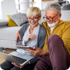 A senior couple shop online together using a tablet.  